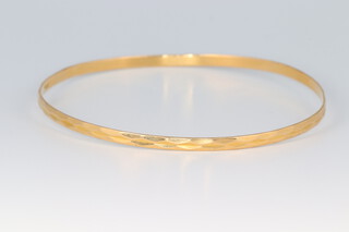 An 18ct engraved gold bangle 7.4g 