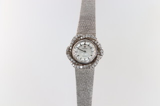 A lady's Omega cocktail wristwatch with silver dial and batons, the movement marked Omega Watch Company 17 jewels 485, contained in an 18ct white gold and diamond encrusted case with integral bracelet, 37g gross excluding movement but including glass and diamonds 