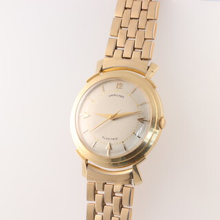 A Hamilton Electric wristwatch with batons and Arabic numerals, contained in a 14ct gold case, the dial marked Hamilton Electric, movement Hamilton 500 Patent Pending, the interior of the back plate marked Hamilton Lancaster PA 14K gold S942040, the outer back plate engraved EC Deering Director Universal Matthey, Regards "A" Directors 1960, on a gilt metal bracelet 