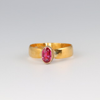 A 22ct gold wedding band set an oval ruby, size J 1/2, 2.1g 