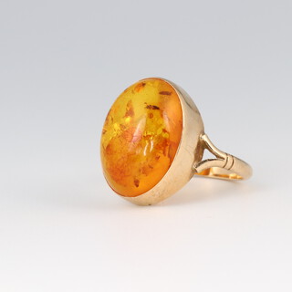 A 9ct gold ring set a cabochon cut section of amber, size O, 3.2g 
