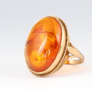 A 9ct gold ring set an oval cut section of amber, size Q, 7.1g 