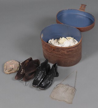 An oval pressed metal hat box containing an embroidered evening bag, a chain mail evening bag, pair of suede lace up boots, pair of black buttoned boots marked Queen and other fabrics 
