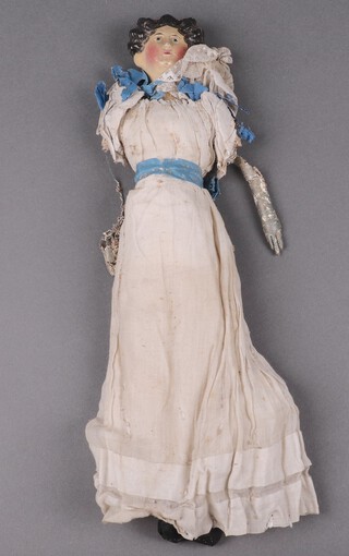 A Regency period papier mache head and shoulders doll, the fabric body filled with sawdust, with original blouse, under garments and head scarf, 42cm l 