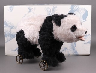 Steiff, a 2008 black and white mohair panda 400452 mounted on rolling wheels with pull string growler, 35cm h x 53cm w, limited edition no.286/1000