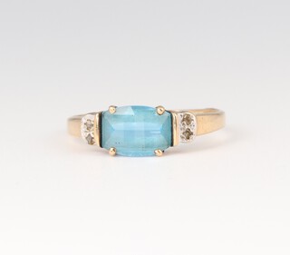 A 9ct gold ring set a rectangular cut topaz supported by diamonds, 1.6g 