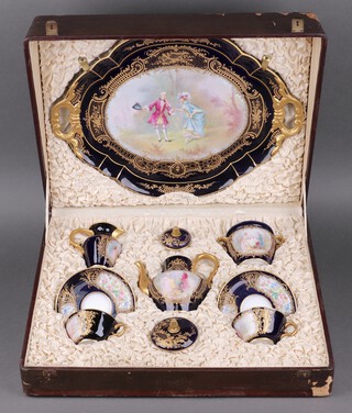 A 9 piece Sevres porcelain cabaret set, decorated a courting couple with blue and gilt banding, comprising twin handled tray 56cm, coffee pot 15cm, twin handled lidded sugar bowl 11cm, cream jug 9cm, 2 cups and 2 saucers, bases marked with Sevres cypher, France