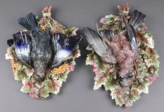 A pair of Majolica plaques decorated game birds against oak leaves 44cm x 29cm 