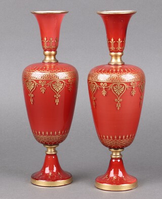 A pair of Victorian red and gilt opaque glass club shaped vases on spreading feet 25cm h 