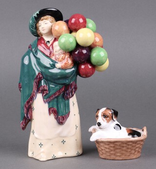 A Royal Doulton figure - The Balloon Seller HN583 base incised 17 23cm together with a Jack Russell puppy in a basket HN2587 7cm 
