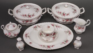 A 55 piece Royal Albert Lavender Rose pattern dinner and tea service comprising 2 twin handled tureens and covers, oval meat plate, sauce boat and stand (sauce boat cracked), 10 dinner plates (contact marks), 9 side plates (1 is a second), 9 tea plates, 10 pudding bowls, milk jug, sugar bowl, 4 tea cups (1 chipped) and 6 saucers together with 2 Queens pepper pots (1 a/f) 