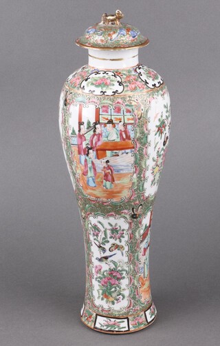 A Canton famille rose porcelain urn of waisted form with panelled decoration decorated figures 41cm h together with an associated lid 