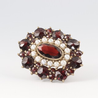 An oval 9ct gold  brooch set garnets and pearls 3cm