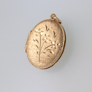 An oval engraved 9ct gold locket 3.9g 