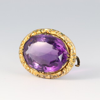 An oval gilt metal brooch set an amethyst 2cm 