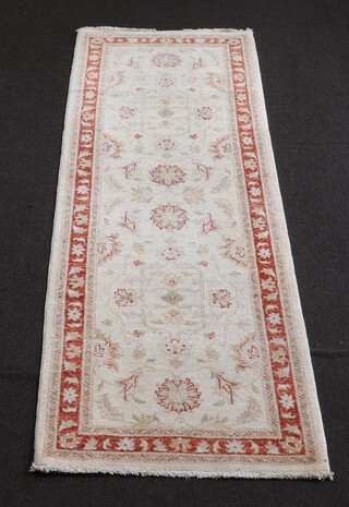 A white and orange ground Afghan style Ziegler runner with floral designs to the centre 251cm l x 82cm w 