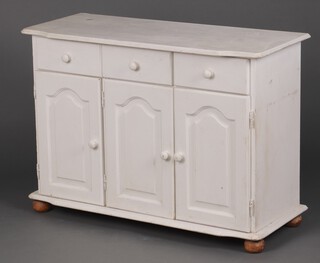A white painted dresser base fitted 3 drawers above triple cupboards, on bun feet 80cm h x 112cm w x 47cm d 