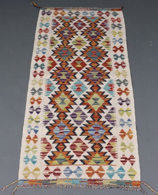A white, tan and green ground Chobi Kilim runner with overall geometric design, 149cm x 66cm