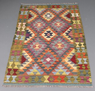 A brown, tan and green ground Meshwani Kilim rug with all over geometric design 158cm x 100cm 