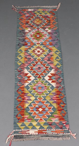 A green and brown ground Chobi Kilim rug with overall geometric design 124cm x 85cm 