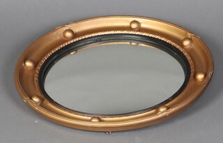 An oval bevelled plate wall mirror contained in a circular gilt ball studded frame 47cm 