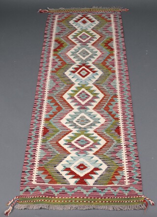 A white, green and orange ground Chobi Kilim runner with diamond design to the centre 196cm x 64cm 