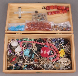 A collection of costume jewellery including necklaces, beads, brooches etc, contained in a box with hinged lid 