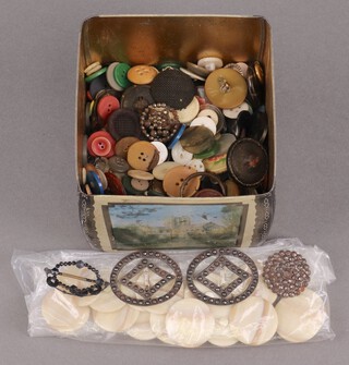 A metal tea caddy containing a collection of buttons 