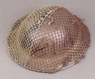 A Second World War British steel helmet with camouflage net (liner loose) 