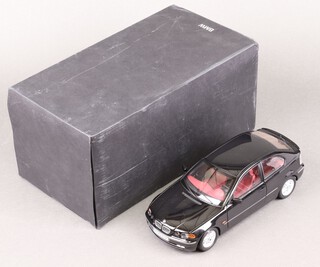A 1:18 scale model of a black BMW 325TI compact car, boxed with polystyrene 