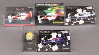 Four 1:42 scale Ayrton Senna Formula One cars by different manufacturers, together with a scale model of Senna's helmet 