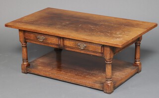 A rectangular oak coffee table fitted 2 drawers with undertier, raised on turned and block supports 48cm h x 122cm w (water and contact marks in places)