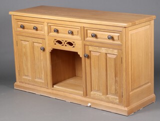 A light oak dog kennel dresser base fitted 3 drawers above a recess flanked by a pair of cupboards 91cm high x 168cm w x 52cm d (water and contact marks in places)