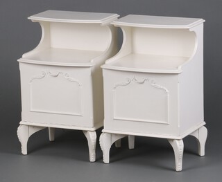 A pair of white painted bow front bedside cabinets with recess above cupboard, raised on cabriole supports 66cm h x 41cm w x 33cm d 