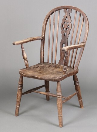 A bleached elm wheel back carver chair with solid seat, on turned supports with H framed stretcher 