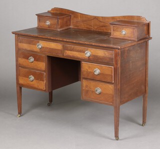 An Edwardian mahogany writing table with raised back, fitted 2 drawers and with leather inset writing surface, above 2 long and 4 short drawers, raised on square tapered supports, brass caps and casters 97cm h x 115cm w x 50cm d 