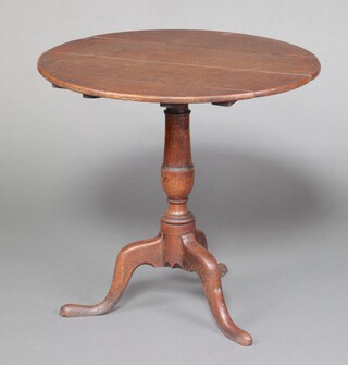An 18th century light oak circular snap top tea table, raised on a pillar and tripod base 71cm h x 74cm diam. 