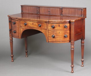 A Georgian mahogany bow front sideboard, the raised back with super structure fitted 3 cupboards enclosed by tambour shutters, the base fitted a drawer flanked by 2 deep drawers, raised on turned and reeded supports 107cm h x 145cm w x 64cm d 