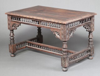 A Victorian rectangular carved oak library/centre table, heavily carved throughout, raised on turned supports with H framed stretcher 73cm h x 119cm w x 79cm d 