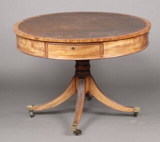 A Georgian circular mahogany drum table with inset brown writing surface, fitted four frieze drawers, raised on a turned column and tripod base 76cm h x 106cm diam. 