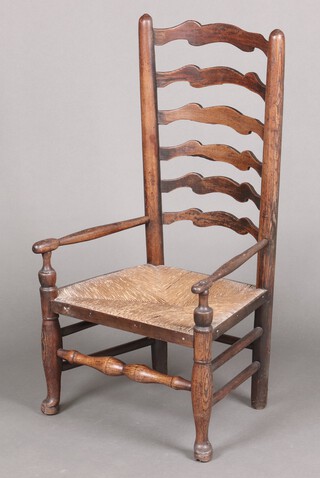 An 18th/19th century low elm ladder back carver chair with woven rush seat 