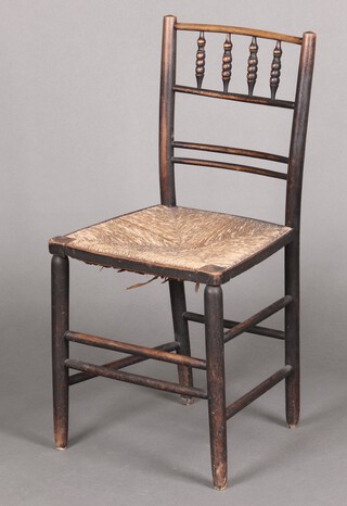 A William Morris ebonised stick and rail back chair with woven rush seat 