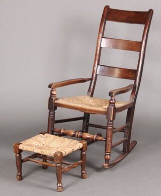 A 19th century elm and beech ladder back rocking chair with woven rush seat, together with a matching stool 
