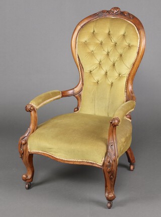 A Victorian carved and bleached walnut open arm chair upholstered in yellow buttoned material, raised on cabriole supports 