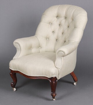 A Victorian tub back armchair upholstered in grey buttoned material, raised on cabriole supports 