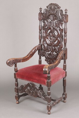 A Victorian, 17th century style, heavily carved and pierced oak open arm chair with arched  cresting rail and overstuffed seat, raised on turned and block supports 