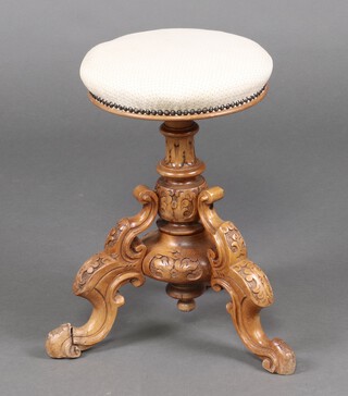 A Victorian carved walnut adjustable piano stool raised on a turned column and tripod base 50cm h x 31cm diam. 
