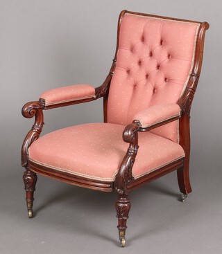 A William IV carved rosewood open arm chair upholstered in pink material, raised on turned supports with brass caps and casters