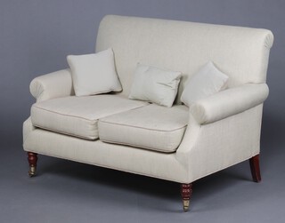 A Victorian mahogany 2 seat sofa upholstered in grey material, raised on turned supports with brass caps and casters 
