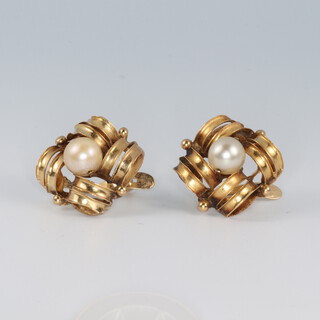 A pair of gold testing as 18ct earrings of floral form, each set a pearl to the centre 4.8g